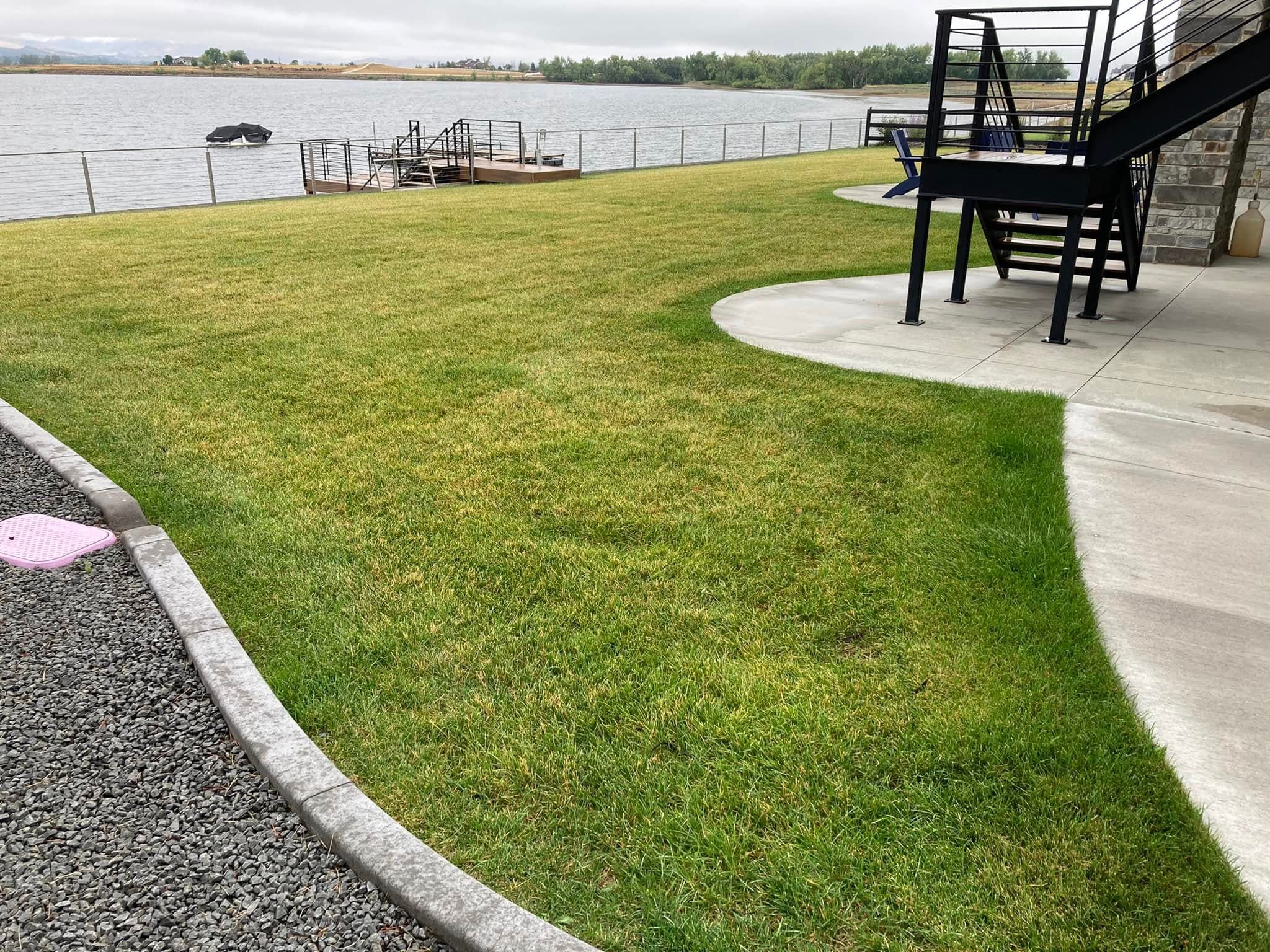 Waterfront property with lush green lawn and patio