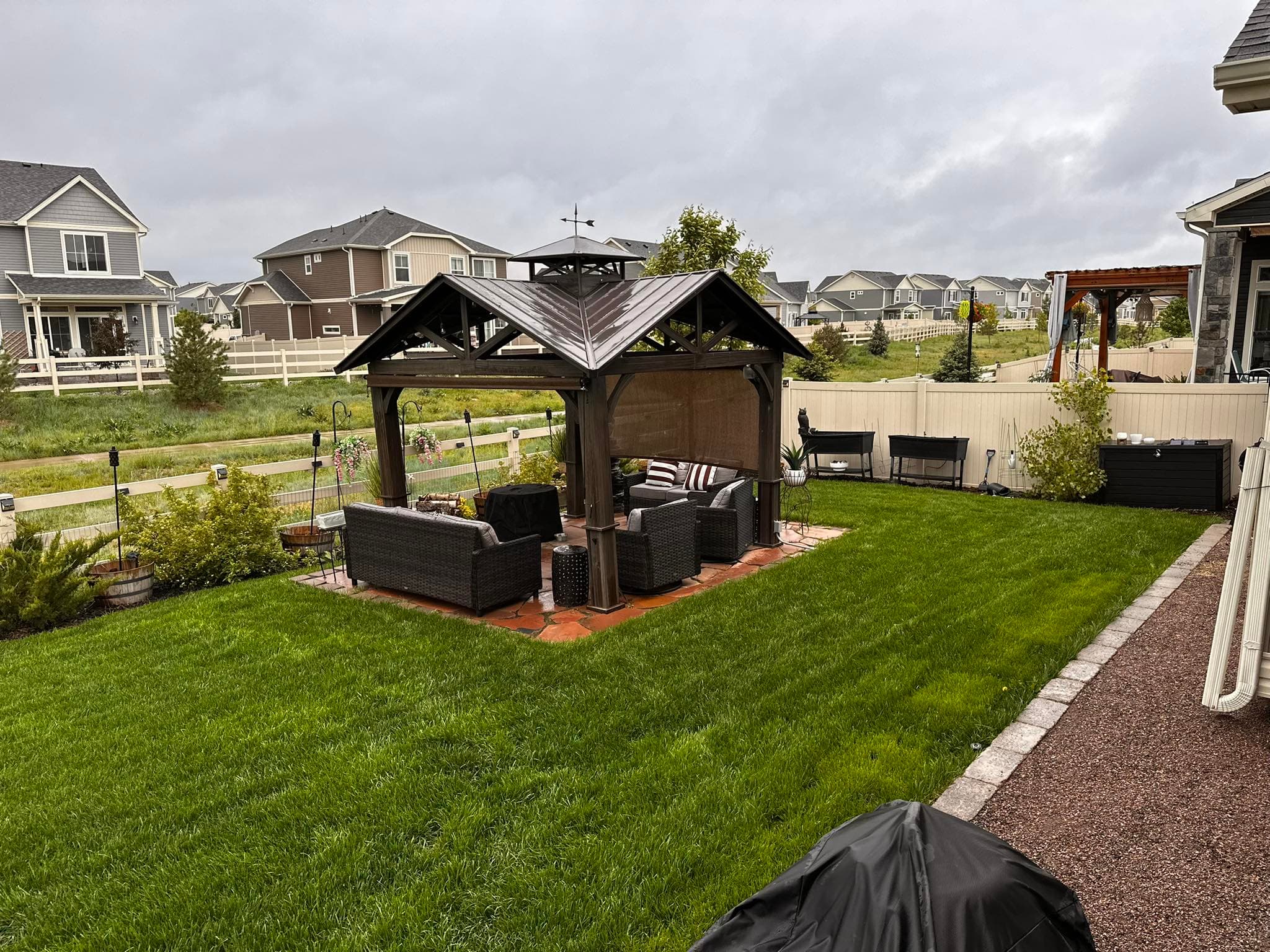 Backyard with wooden gazebo and manicured lawn