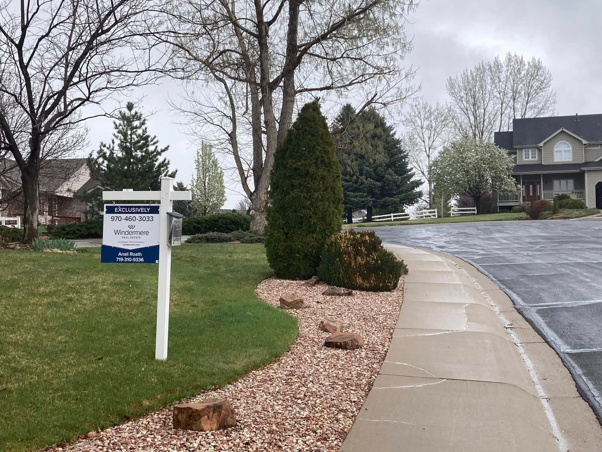 Driveway entrance with company sign and decorative stone