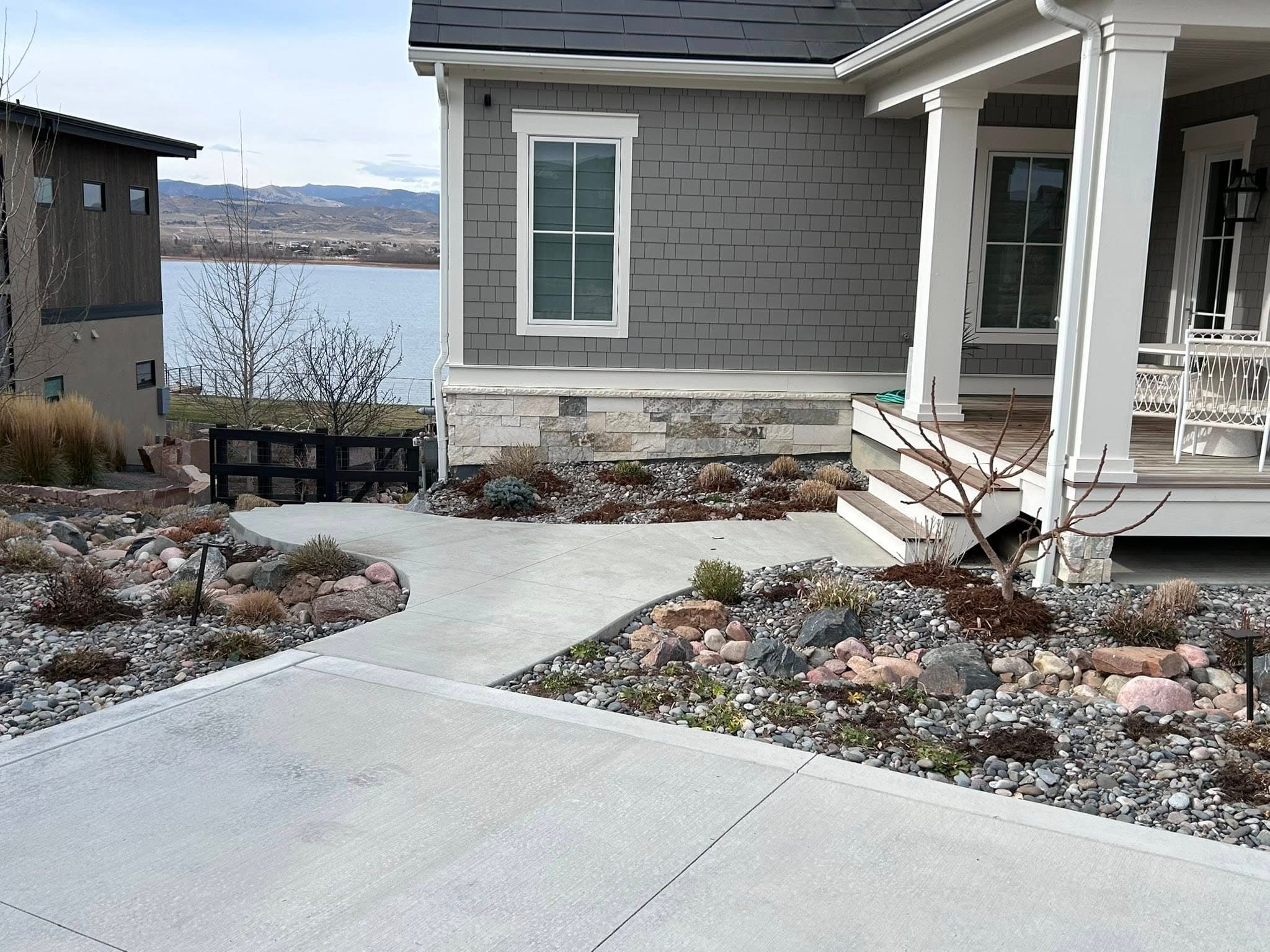 Stamped concrete patio with river rock landscaping and mountain lake view